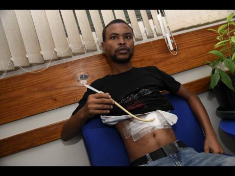 Andrae Greenland shows his feeding tube, which he needs to use since he has great difficulty swallowing solid food.