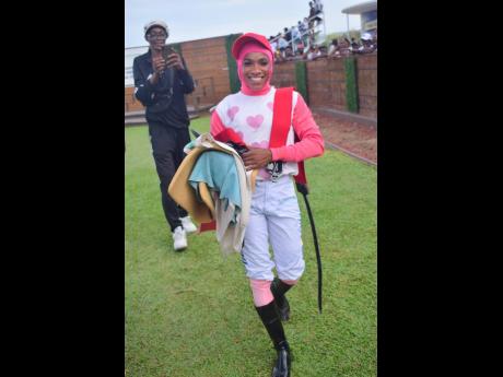 Female jockey Abigail Able is all smiles as she carries her riding equipment after guiding SENSATIONAL SOUL to victory in the eighth race over 9 furlongs and 25 yards at Caymanas Park on Saturday, June 7.