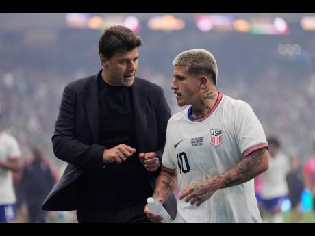 Credit: AP United States head coach Mauricio Pochettino (left) talks with midfielder Diego Luna (10) as they walk off the field at halftime during Sunday’s Concacaf Gold Cup final against Mexico in Houston.