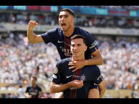 Paris Saint-Germain’s Fabian Ruiz (bottom) celebrates with teammate Achraf Hakimi after scoring his side’s third goal during the Club World Cup semi-final  match between PSG and Real Madrid in East Rutherford, New Jersey yesterday.