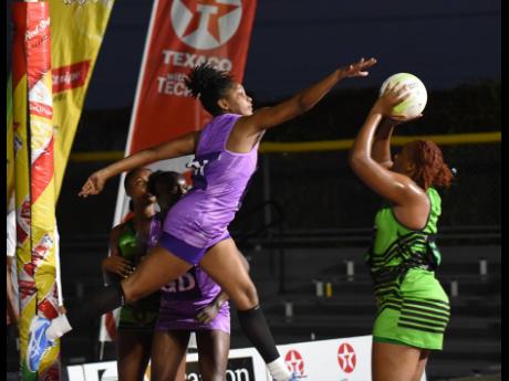Credit: Ian Allen Dhanyel Johnson (left) of St Ann Orchids attempts to block a shot from Manchester Spurs’ Amanda Pinkney during the Elite Netball League playoff match held at the Leila Robinson Courts on Sunday.