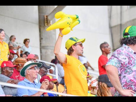 Credit: Matthew McKoy An Australian fan (centre) cheers for his team on day three of the third West Indies versus Australia Test at Sabina Park yesterday.