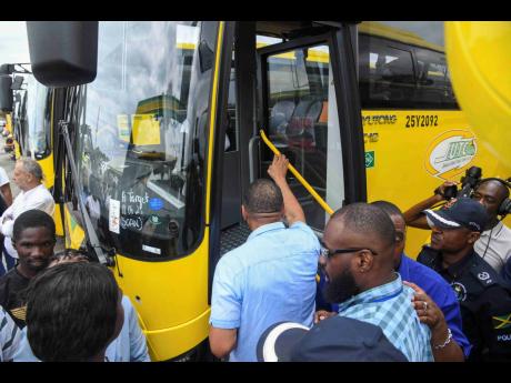 Credit: Antoine Lodge Prime Minister Dr Andrew Holness boards one of the new Jamaica Urban Transit Company buses at the company’s Portmore depot in Braeton, St Catherine on Wednesday.