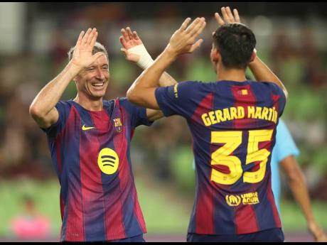 Credit: AP FC Barcelona’s Robert Lewandowski (left) celebrates with his teammate Gerard Martin after scoring a goal during a friendly soccer match against Daegu FC at the Daegu Stadium in Daegu, South Korea, on Monday, August 4.