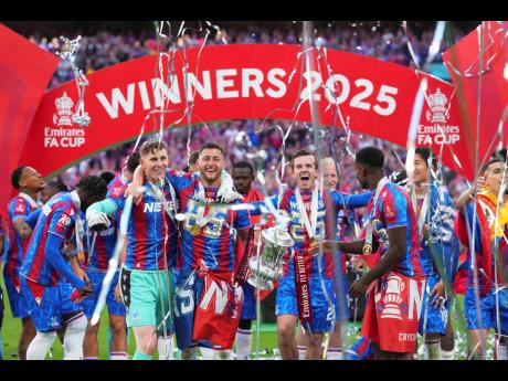 Credit: AP Crystal Palace players celebrate with the trophy after winning the English FA Cup final soccer match against Manchester City at Wembley stadium in London on Saturday, May 17.