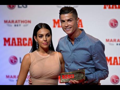 Credit: AP Soccer player Cristiano Ronaldo poses with his partner, model Georgina Rodriguez, in Madrid on July 29, 2019.