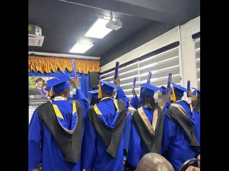 Inmate graduates raise their diplomas in celebration after receiving their degrees, conferred by the President of the University of the Commonwealth Caribbean.
