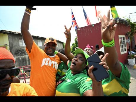 PNP supporter Winston Wilson (left) having a good time with his JLP friends in Morant Bay, St Thomas.