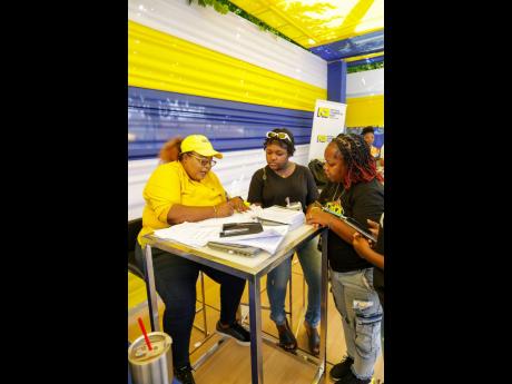 Credit: Contributed Rochelle Wellington (left), retail sales support officer at NCB, assists 13-year-old Steer Town Academy student Devhanna Martin (centre) with opening an NCB START account to kick-start her savings using the $6,000 voucher she won at NCB’s Sum’n Nice fi Dem Future Back-to-School Fair at the St Ann’s Bay branch. Devhanna’s mother, Devenia Royes, looks on.