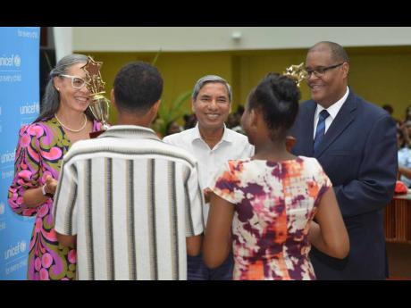 Credit: Antoine Lodge Dr Diana Thorburn (left), chair for the Child Protection and Family Services Agency’s (CPFSA) advisory board; Mohammad Mohiuddin (centre), deputy representative for UNICEF Jamaica; and Newton Douglas, director of policy, planning and evaluation at CPFSA; congratulate the most outstanding boy and girl at the CPFSA’s PEP Awards Ceremony held on Thursday at the Jamaica Conference Centre in Kingston.