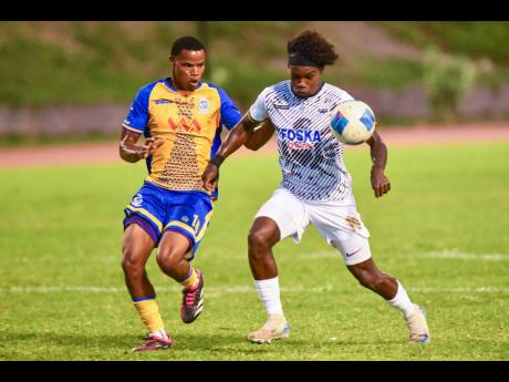 Conner James (right) of Cavalier SC plays the ball while being challenged by Raje Ximines of Harbour View FC during the Jamaica Premier League football match at Stadium East yesterday. The game ended 0-0.