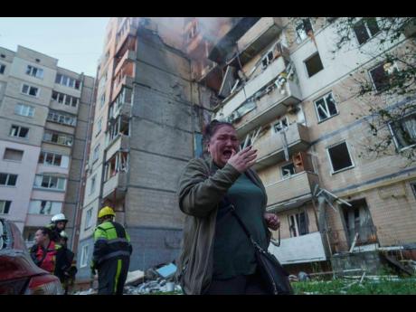 A woman reacts in front of a residential building heavily damaged by a Russian strike in Kyiv, Ukraine, yesterday.