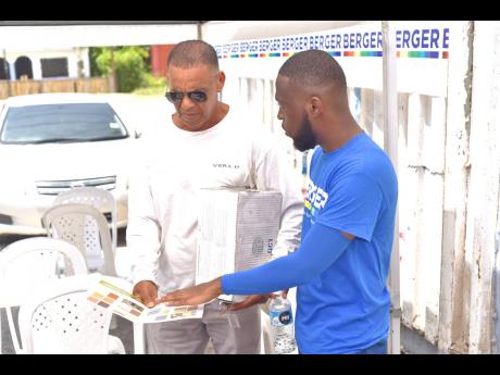 Credit: Contributed Phots Berger Paints Jamaica chemist Shomar Scott (right) showcases the vibrant Trowel-On colour range to Prince Lewis at the Westmoreland leg of the roadshow.