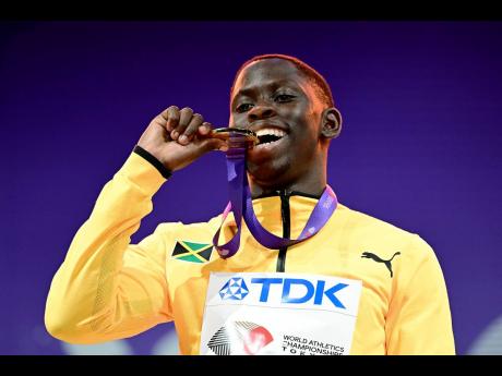 Credit: Gladstone Taylor World champion in the men’s 100m, Jamaica’s Oblique Seville, takes a bite of gold as he stands on the medal podium during the presentation ceremony of the World Athletics Championships Tokyo 2025 at the Japan National Stadium in Tokyo, Japan, yesterday.