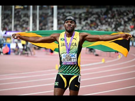 Credit: Gladstone Taylor Jamaica’s 110-metre hurdles silver medallist Orlando Bennett celebrates with the national flag.