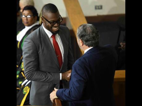 Ramon Small-Ferguson, son of Dr Fenton Ferguson, shakes hands with senate president Tom Tavares-Finson.