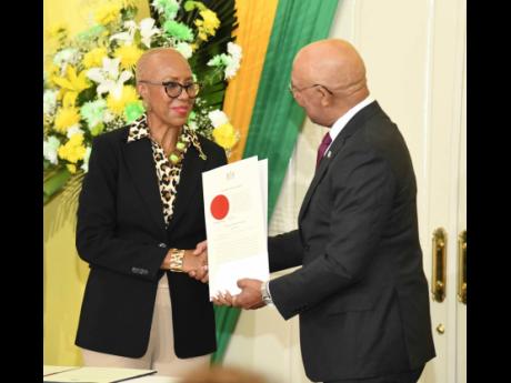 The Minister of Finance earns just over $24.5 million per year or $2.04 million each month. Here, the finance minister, Fayval Williams, collects her instrument of appointment from Governor-General Sir Patrick Allen.