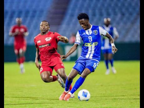 Credit: Courtesy of conacacaf.com Mount Pleasant Football Academy’s Daniel Green (right) tries to evade the chasing Emmanuel Thomas of Central FC during their Group A Concacaf Caribbean Cup football match at the Hasely Crawford Stadium in Trinidad on Tuesday night. Mount Pleasant won 2-0.