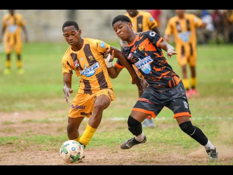 Credit: Matthew McKoy Ryan Francis (right) of Tivoli Gardens and Sheid O’Gilvie of Haile Selassie fight for possession of the ball during the Manning Cup football match: at Tivoli Gardens High School in Kingston on Friday. The game ended 2-2.