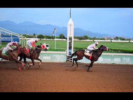 Credit: Anthony Minott/Freelance Photographer UNSPUN (right), ridden by Reyan Lewis, wins the Typewriter Trophy feature event ahead of INTRESTNTIMESAHEAD (Shane Ellis) and PROVIDENT (left), Phillip Parchment) at Caymanas Park yesterday.