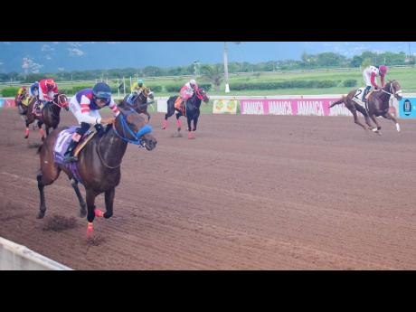 BOOTYLICIOUS (left), ridden by Raddesh Roman, winning Division One of the Nigel Nunes Memorial Cup ahead of PRINCE AMANN (right, Robert Halledeen) at Caymanas Park yesterday.