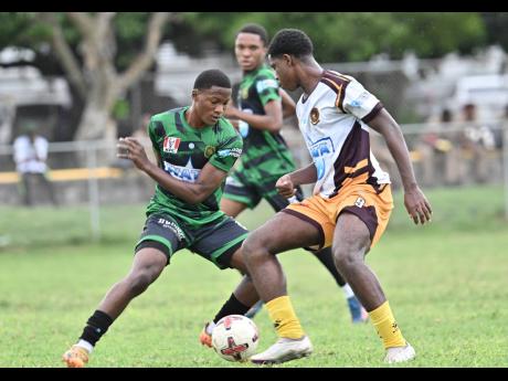 Credit: Rudolph Brown Kimani Thompson (left) of Calabar High School and Alex Wright of Wolmer’s Boys’ School challenge for the ball during the ISSA WATA Manning Cup football match at Wolmer’s Boys’ School on Tuesday. Calabar won 2-1.