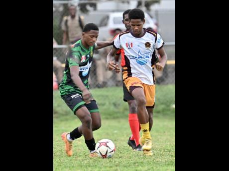 Kimani Thompson (left) of Calabar High looks to play the ball while coming under pressure from Jordan Brown of Wolmer’s Boys’ School during the ISSA WATA Manning Cup football match at Wolmer’s Boys’ School on Tuesday. Calabar won 2-1.