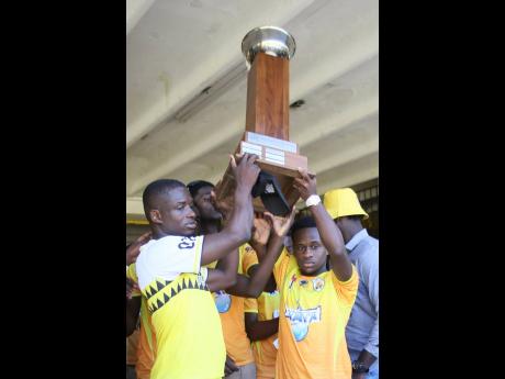 Credit: File Garvey Maceo High’s head coach Lester Hibbert (left) and team captain Christopher Mundle lift the daCosta Cup during celebrations at the school on Monday, December 9, 2024.