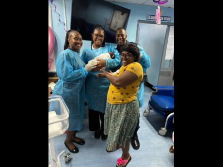 Credit: Contributed Members of the Jamaica Constabulary Force (from left) Constable Shaniah Salmon, Constable Nicole Williams and Sergeant Kidan McCoy are all smiles with Michaela Dawson and her newborn. The cops helped deliver the child and then transported mom and baby to the Victoria Jubilee Hospital.