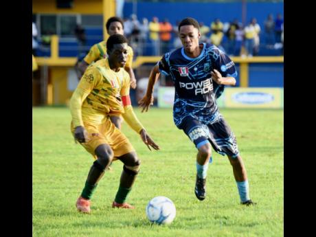 Credit: Ashley Anguin The Manning’s School’s Devardo Reid (right) tries to dribble past B.B. Coke High’s captain Yandria Morgan during their Group 3 ISSA daCosta Cup second-round football game at STETHS yesterday.Manning’s won 2-0.