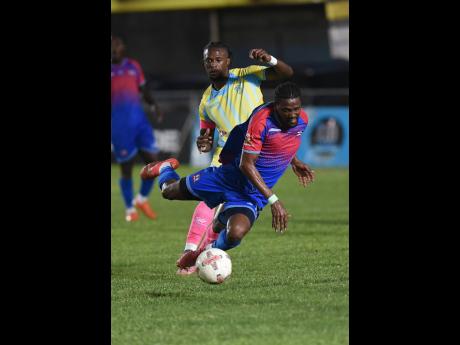 Credit: Ian Allen Nevaun Turner (front) of Dunbeholden FC is tripped by Revaldo Mitchell of Waterhouse FC during their Jamaica Premier League football match at Drewsland Mini Stadium on Sunday. The game ended 0-0.