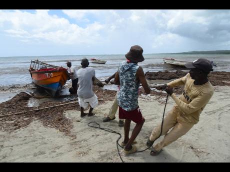 Fishermen at Rocky Point, St Thomas, move their boat to higher ground in anticipation of Tropical Storm Melissa hitting the island.