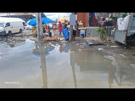 Credit: Almando Smith Vendors say that sewage at the corner of Rose Lane and Pechon Street in downtown Kingston is keeping customers away, as they try to earn some sales before the storm hits.