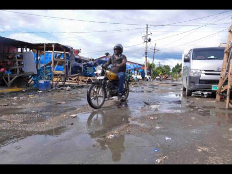 Credit: Antoine Lodge A motorcyclist makes his way past Coronation Market in downtown Kingston.