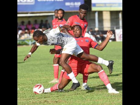 Credit: Ian Allen/Photographer Romarion Thomas (left) of Cavalier is fouled by Richard Brown (right) of Spanish Town Police FC during their Jamaica Premier League football match at Drewsland Mini Stadium on Sunday, October 19. Cavalier won the game 3-0.