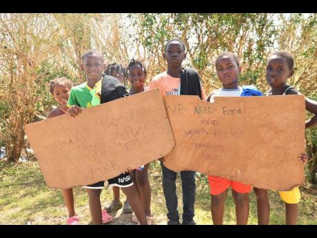Credit: Matthew McKoy A group of children plead for help along a main road in St Elizabeth.