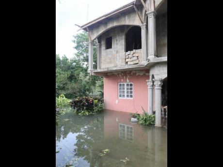 Credit: Nathaniel Stewart Floodwaters rise around a family’s home in Content, Manchester.