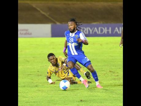 Credit: Antoine Lodge/Photographer Mount Pleasant Football Academy’s Demario Phillips dribbles away from Defence Force’s Kaihim Thomas during their Concacaf Caribbean Cup football match at the National Stadium in Kingston last night. Defence Force of Trinidad and Tobago won 1-0. Mount Pleasant FA won the tie 5-2 on aggregate, after winning the first leg 5-1 in Trinidad.