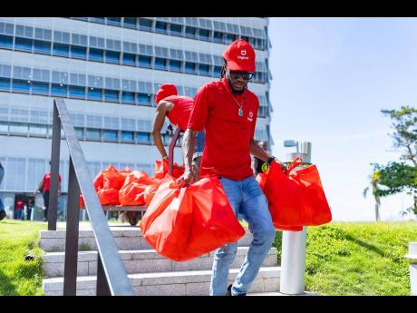 A Digicel team member with care packages for distribution.
