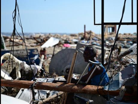 Credit: Gladstone Taylor/Multimedia Photo Editor A man sits by the roadside on High Street in Black River, St Elizabeth, surrounded by debris resulting from the passage of Hurricane Melissa.