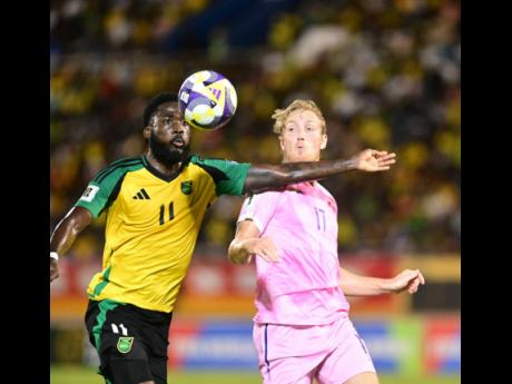 Jamaica’s Shamar Nicholson (left) moves to control the ball ahead of Bermuda’s Harry Twite during their Concacaf Group B World Cup Qualifying match at the National Stadium last night.  Jamaica won 4-0. 