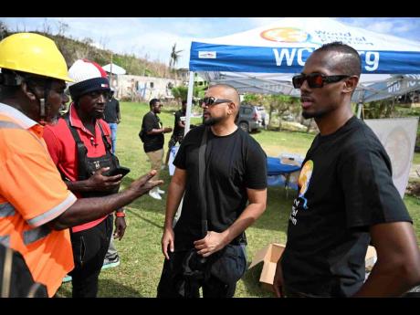 Credit: Photos by Ricardo Makyn/Chief Photo Editor Dancehall artiste Sean Paul (second right) and Chef Brian Lumley (right) engage with community organisers in Beeston Spring, Westmoreland, during ongoing relief efforts for victims of Hurricane Melissa.