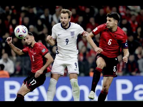 England’s Harry Kane (centre) scores his side’s second goal as Albania’s Naser Aliji (left) and Berat Djimsiti try to stop him during the World Cup 2026 group K qualifying soccer match in Tirana, Albania, yesterday. England won 2-0.