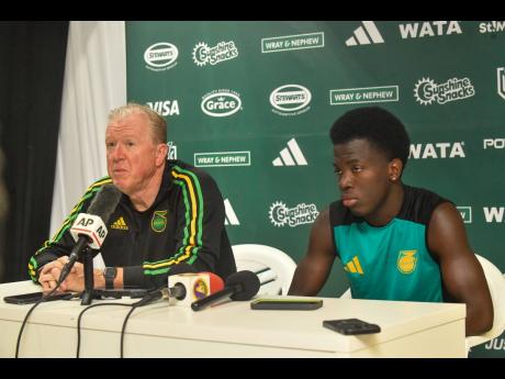 Credit: Matthew McKoy Steve McClaren (left) , head coach for the Reggae Boyz, speaks about his hopes and expectations for the team, while striker Kaheim Dixon looks on during the pre-game press conference at the National Stadium in Kingston yesterday. Jamaica will play against Curaçao in a Concacaf World Cup Qualifying football match today.