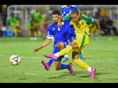 Credit: Matthew McKoy Roshon Van Ejima (left) of Curaçao fails to stop a shot from Jamaica’s Bobby De Cordova-Reid during the Concacaf World Cup Qualifying football match at the National Stadium in Kingston on Tuesday night. The game ended 0-0.