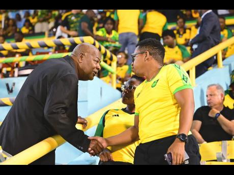 Jamaica Football Federation President Michael Ricketts (left) shakes the hand of a fan in the grandstand during the FIFA World Cup Qualifier against Curaçao at the National Stadium in Kingston on Tuesday.