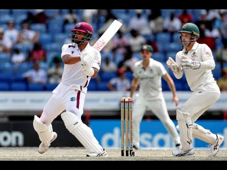 West Indies’ Brandon King (left) plays a pull shot against Australia during day two of the second cricket Test match at National Cricket Stadium in St. George’s, Grenada on Friday, July 4. Looking on is Australia wicketkeeper Alex Carey.