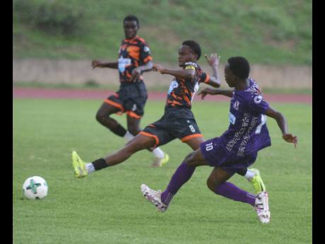 Credit: Ian Allen Shareef Ricketts (right) of Kingston College (KC) makes a pass while Malachi Rose (centre) and Jeremy Forbes of Tivoli Gardens High School react during their ISSA WATA Manning Cup football match at Stadium East on Wednesday, October 1. KC won 4-0.