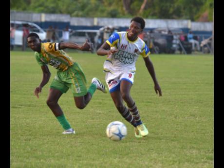 St Elizabeth Technical High School’s Kaieem Lewis (right) tries to outrun  Ocho Rios High’s Kawayne McInnis during their ISSA daCosta Cup round-of-16 football match at Drax Hall Sports Complex on Tuesday.