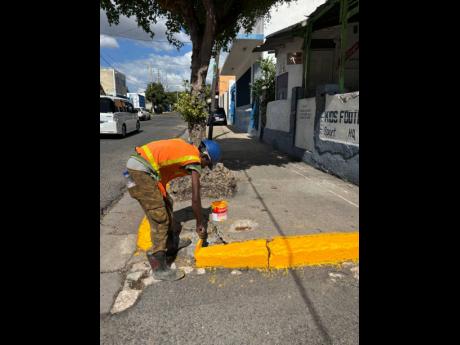 A worker applies a coat to this section of North Street in Kingston.